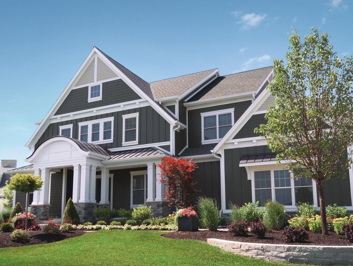 A dark gray house with white trim.