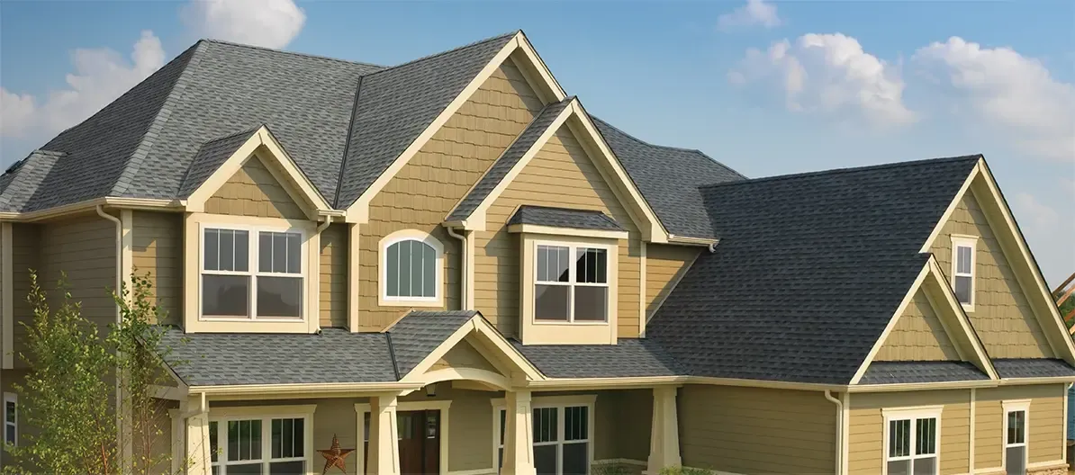 A newly-installed, gray residential roof on a tan house.