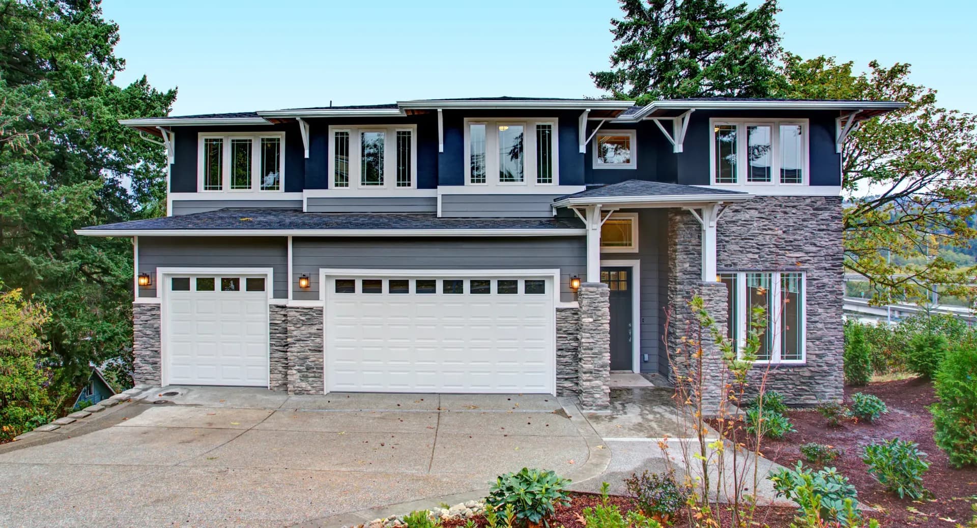 Stone Veneer siding installed on a blue and gray home with white trim.